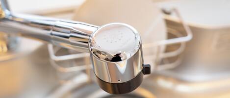 A kitchen faucet with a metallic finish and a control knob.