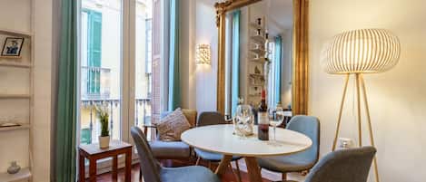 A dining area with a round table, chairs, a mirror, and a floor lamp.