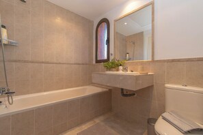 Un baño moderno con bañera, lavamanos e inodoro.