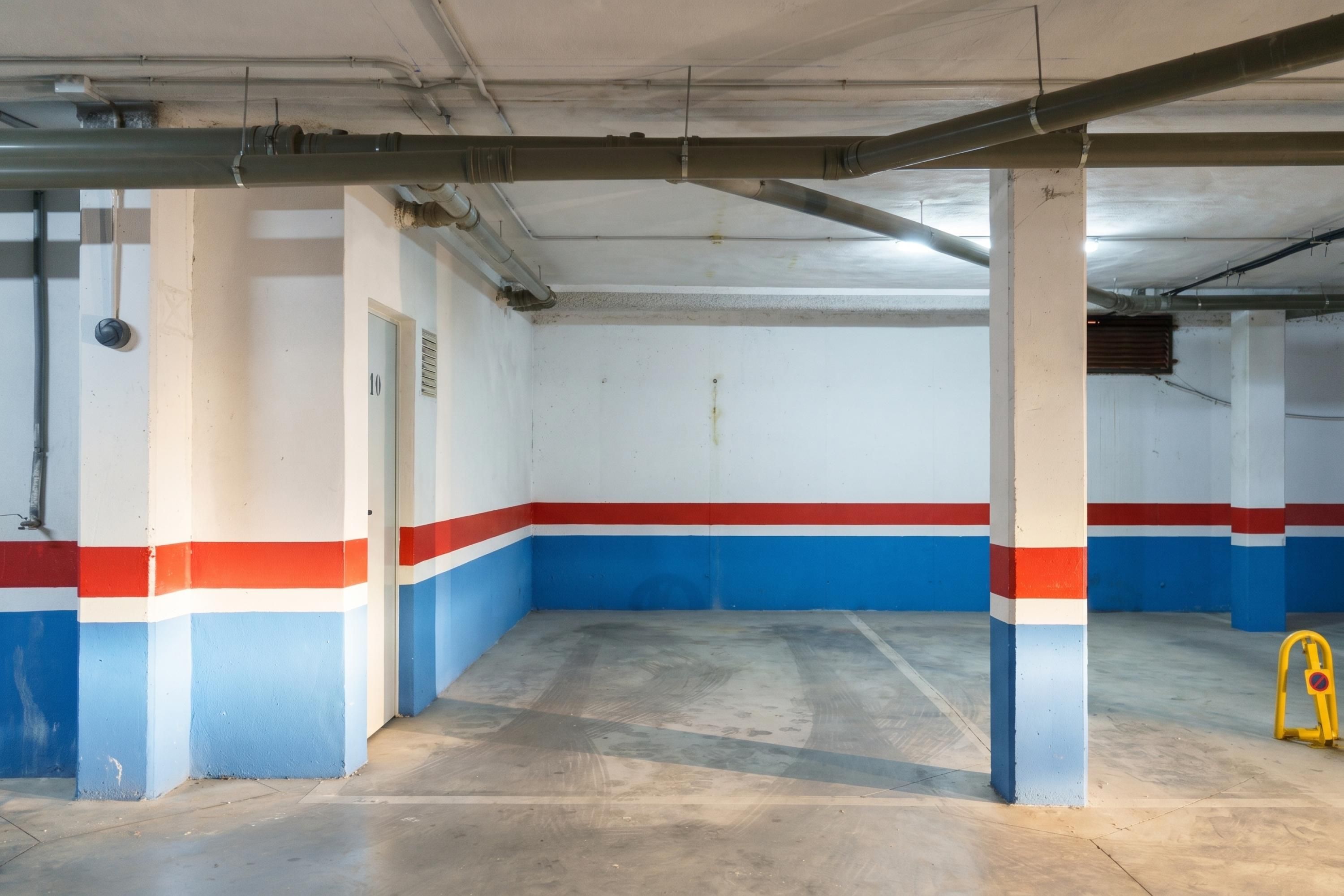 A parking garage with concrete pillars, a yellow caution sign, and a door marked '10'.