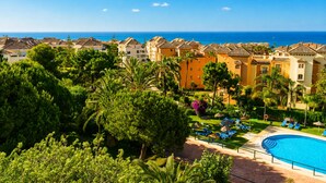 Ein Resort mit Swimmingpool, Palmen und Meerblick.