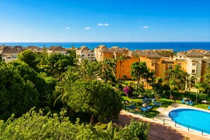 A resort with a swimming pool, palm trees, and ocean views. - Marbella Este Next Marriott and Nikki B (Marbella)