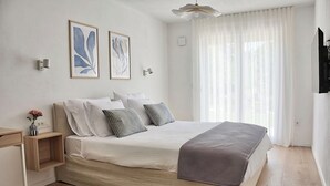A bedroom with a bed, bedside tables, a desk, and a window with curtains. - Villa Onda with private pool and BBQ near Rovinj (Rovinjsko Selo)