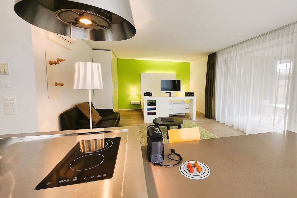 A modern kitchen with a built-in induction cooktop, a coffee machine, and a kettle.