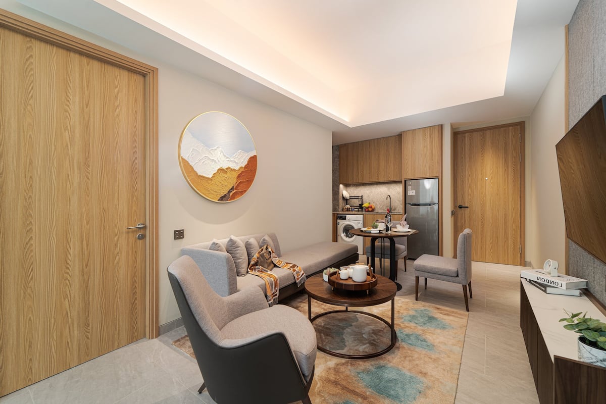 Een moderne woonkamer met een bank, salontafel en een eethoek met een tafel en stoelen.
