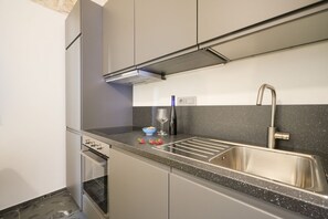 Réfrigérateur, un four, surface de cuisson, vaisselle et ustensiles