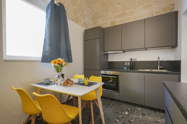 Réfrigérateur, un four, surface de cuisson, vaisselle et ustensiles