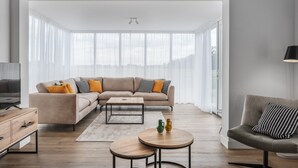 Ein modernes Wohnzimmer mit einer Eckcouch, einem Couchtisch und einem runden Tisch.