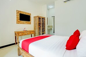 A bedroom with a bed, a wooden nightstand, a mirror, and a wardrobe.