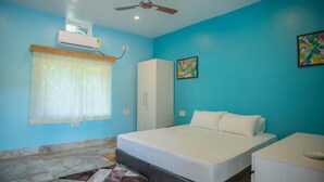 A bedroom with a bed, a wardrobe, a ceiling fan, an air conditioning unit, and a window with curtains. - Michael's Island Resort (Brahmagiri)