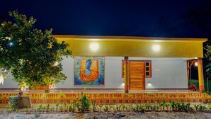 A building with a large mural, a wooden door, and a tiled entrance. - Michael's Island Resort (Brahmagiri)