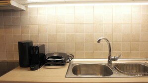 A kitchen with a stainless steel sink, a coffee maker, and a Krups appliance. - Alkinoos Apt -Inspiring Living in Meteora -3BD (Kalampaka)