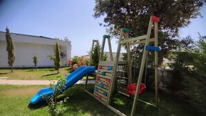 Ein Spielplatz mit einer blauen Rutsche und einer Kletterkonstruktion.