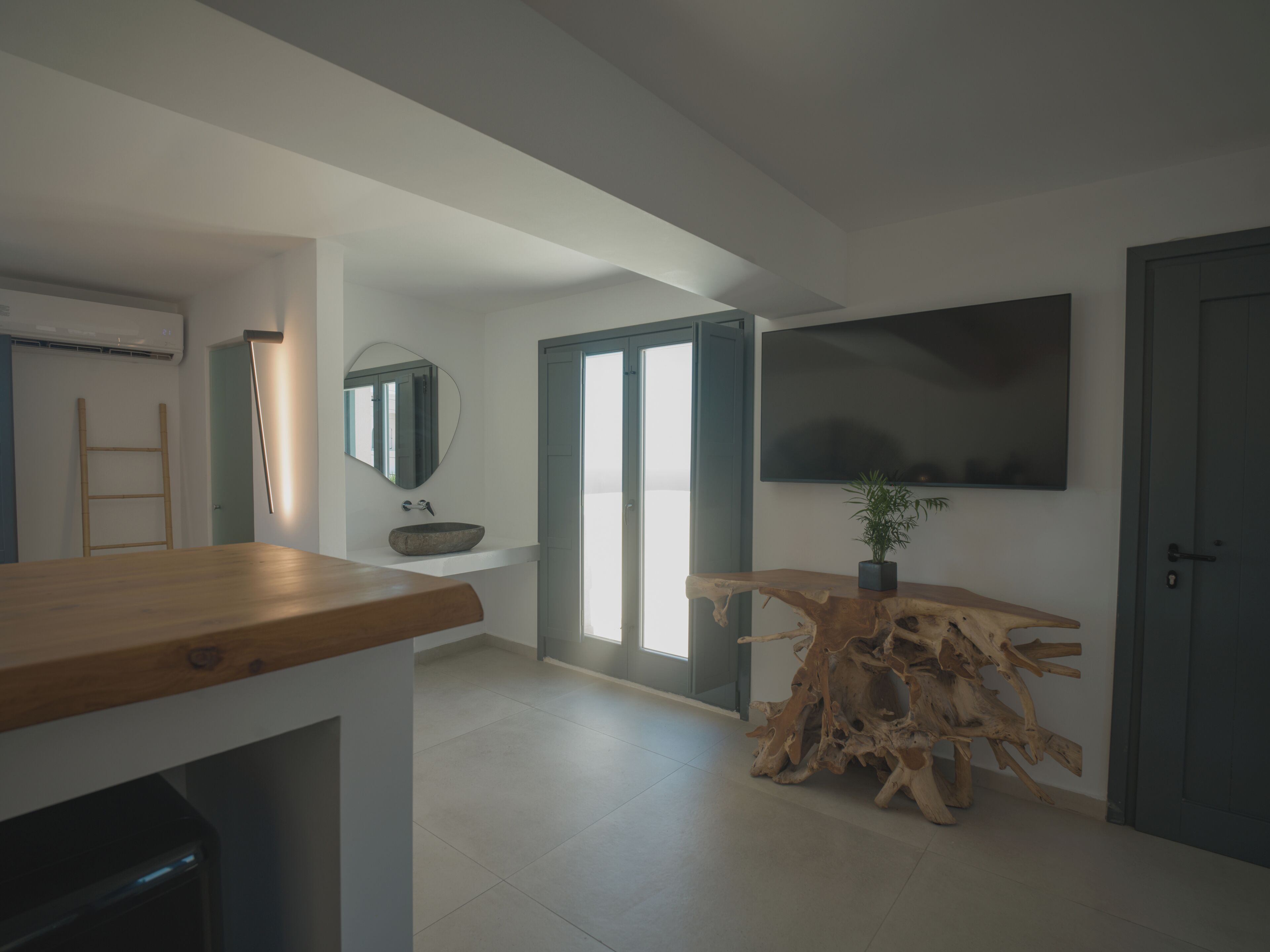 A modern kitchen with a wooden countertop, a built-in sink, and a large mirror.