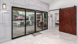 Um hall de hotel moderno com porta de vidro que dá para uma área de estar ao ar livre.