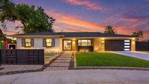 Une maison moderne à deux étages, dotée d’une pelouse bien entretenue, d’une allée et d’un garage.