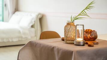 Una mesa con un florero tejido, una vela y una hogaza de pan.