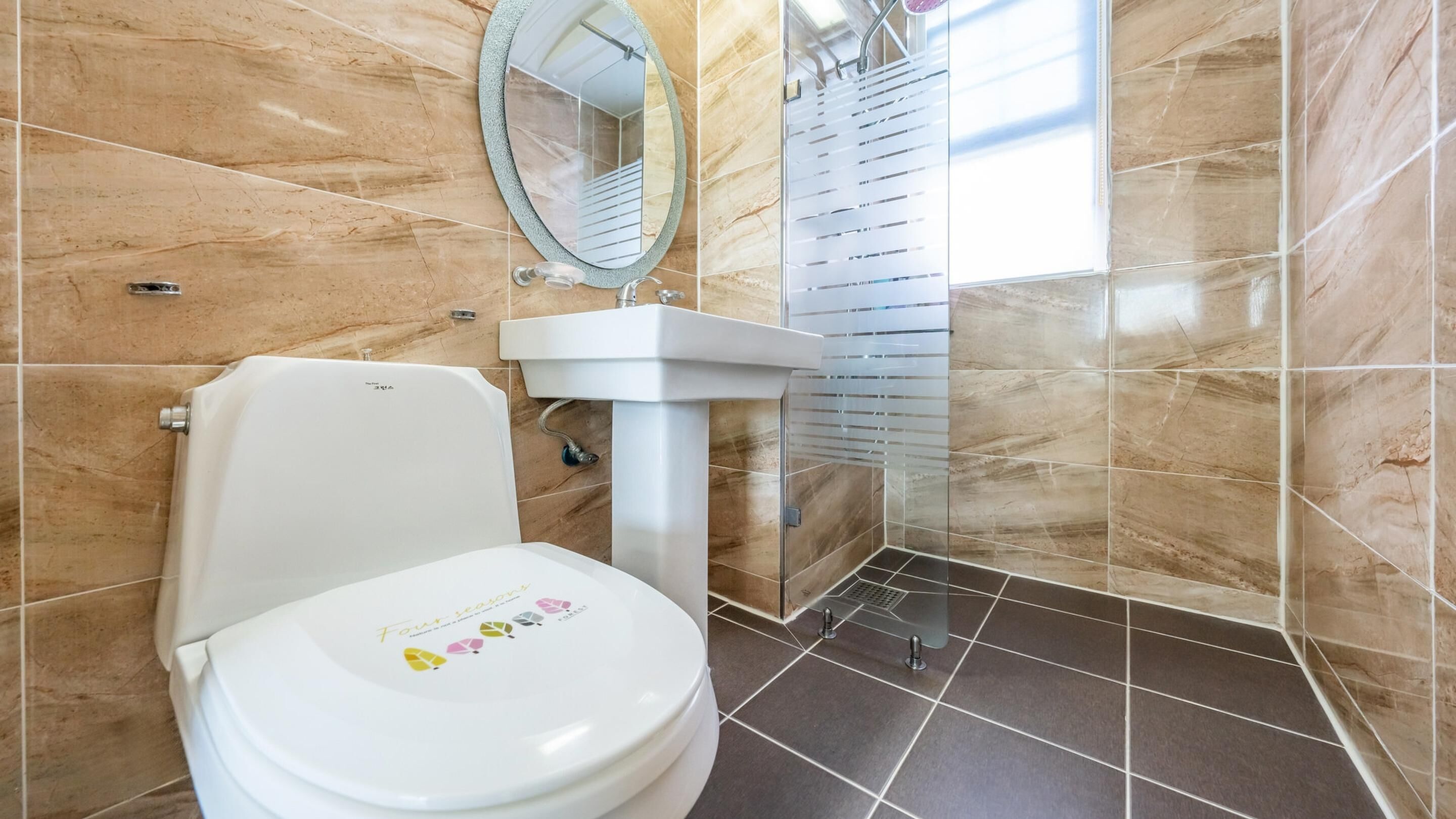 Ein Badezimmer mit Toilette, Waschbecken und Duschbereich.