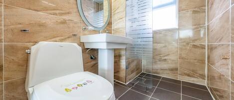 Ein Badezimmer mit Toilette, Waschbecken und Duschbereich.