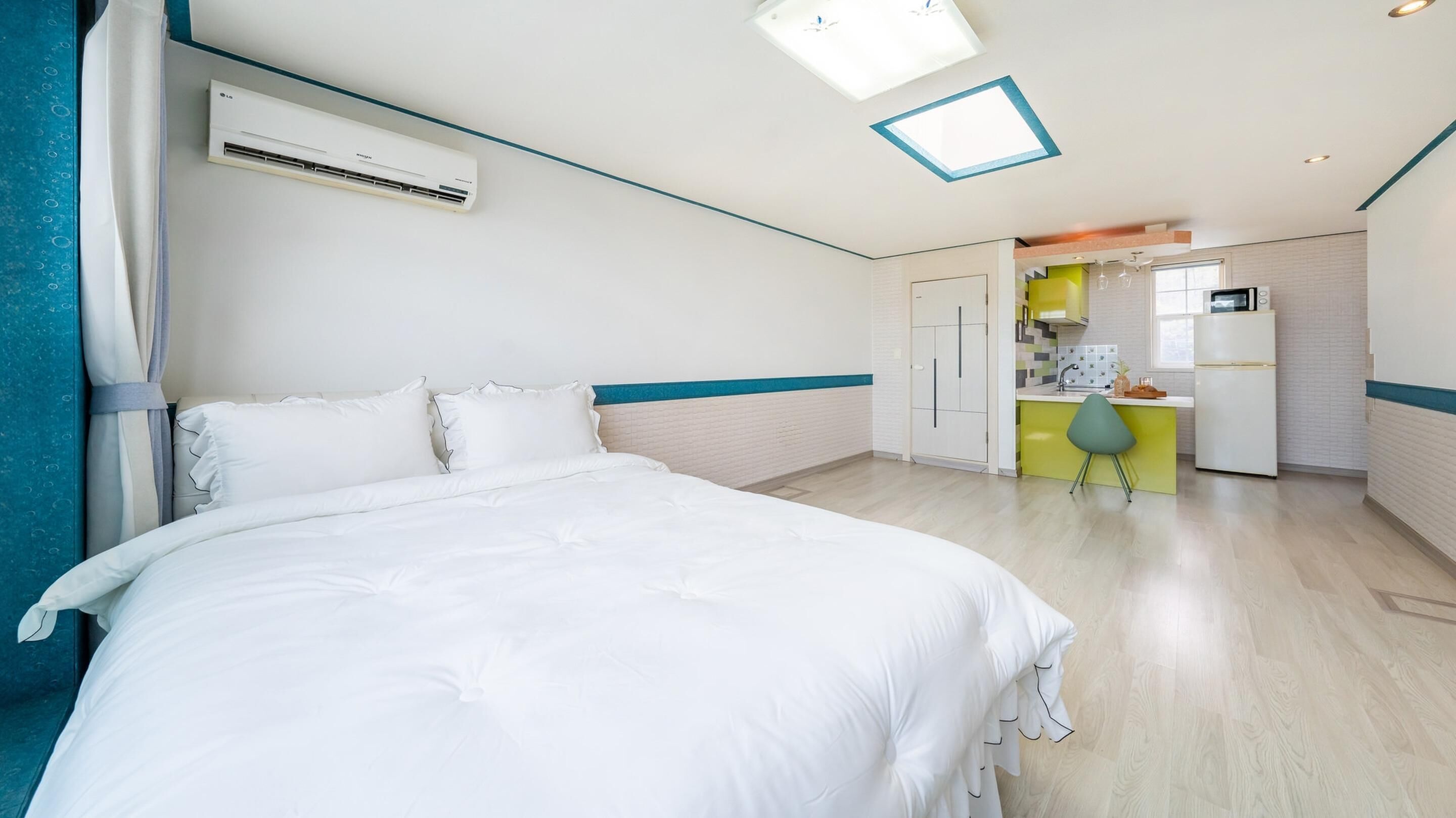 Een hotelkamer met een bed, een airconditioning, een kitchenette en een badkamer.