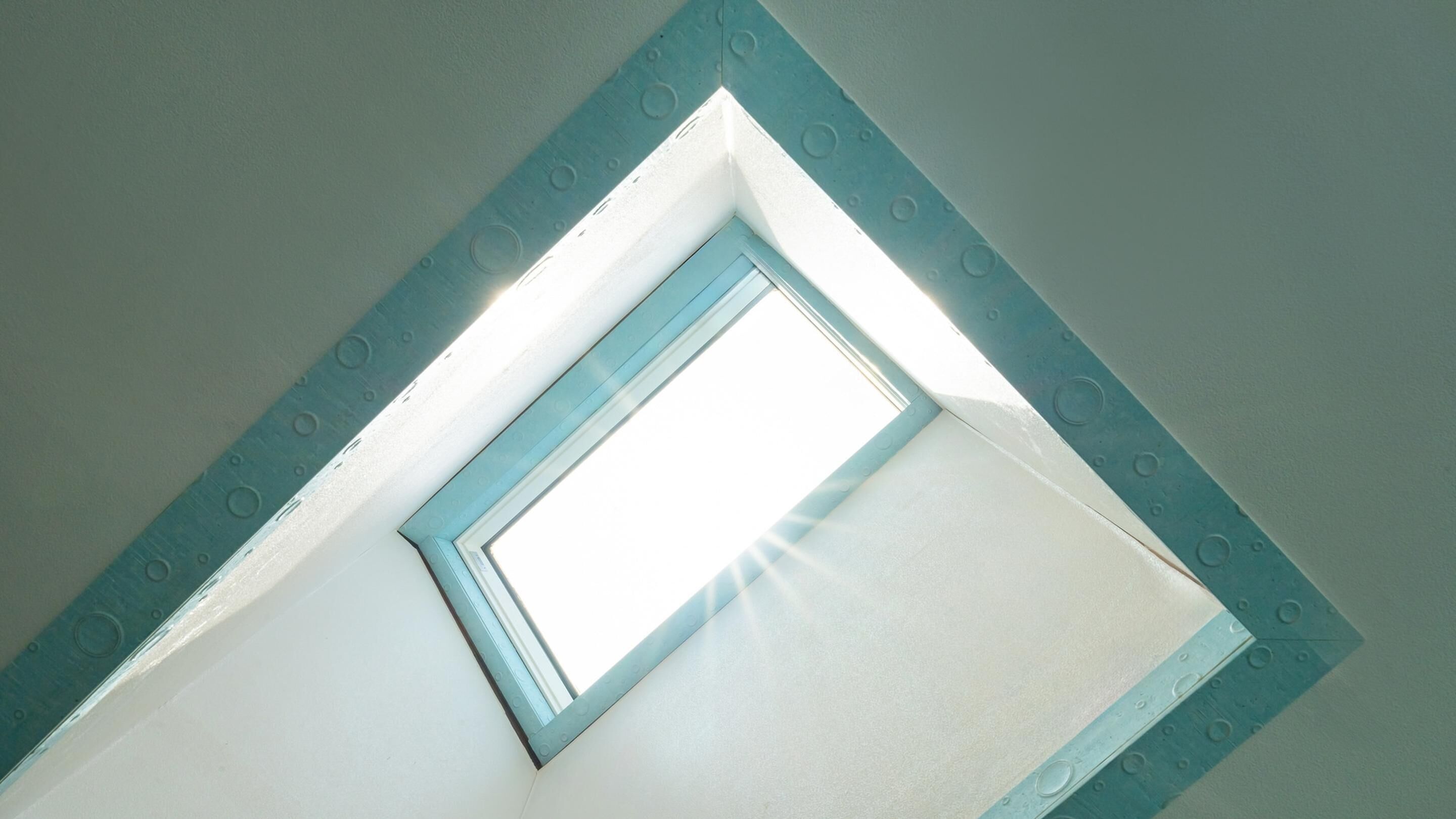 A skylight in a room with a white ceiling and a blue frame.