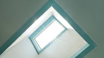 A skylight in a room with a white ceiling and a blue frame.