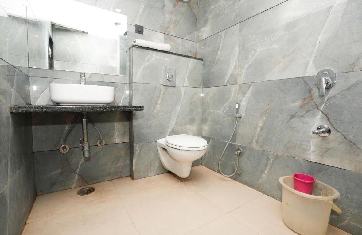 Un baño con lavamanos, inodoro y ducha blancos.