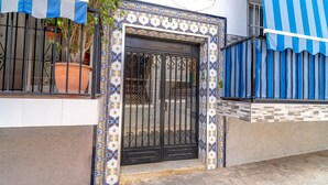 A house with a black gate, blue and white patterned tiles, and a potted plant on the balcony. - Urban Comfort by Casasol (Nerja)