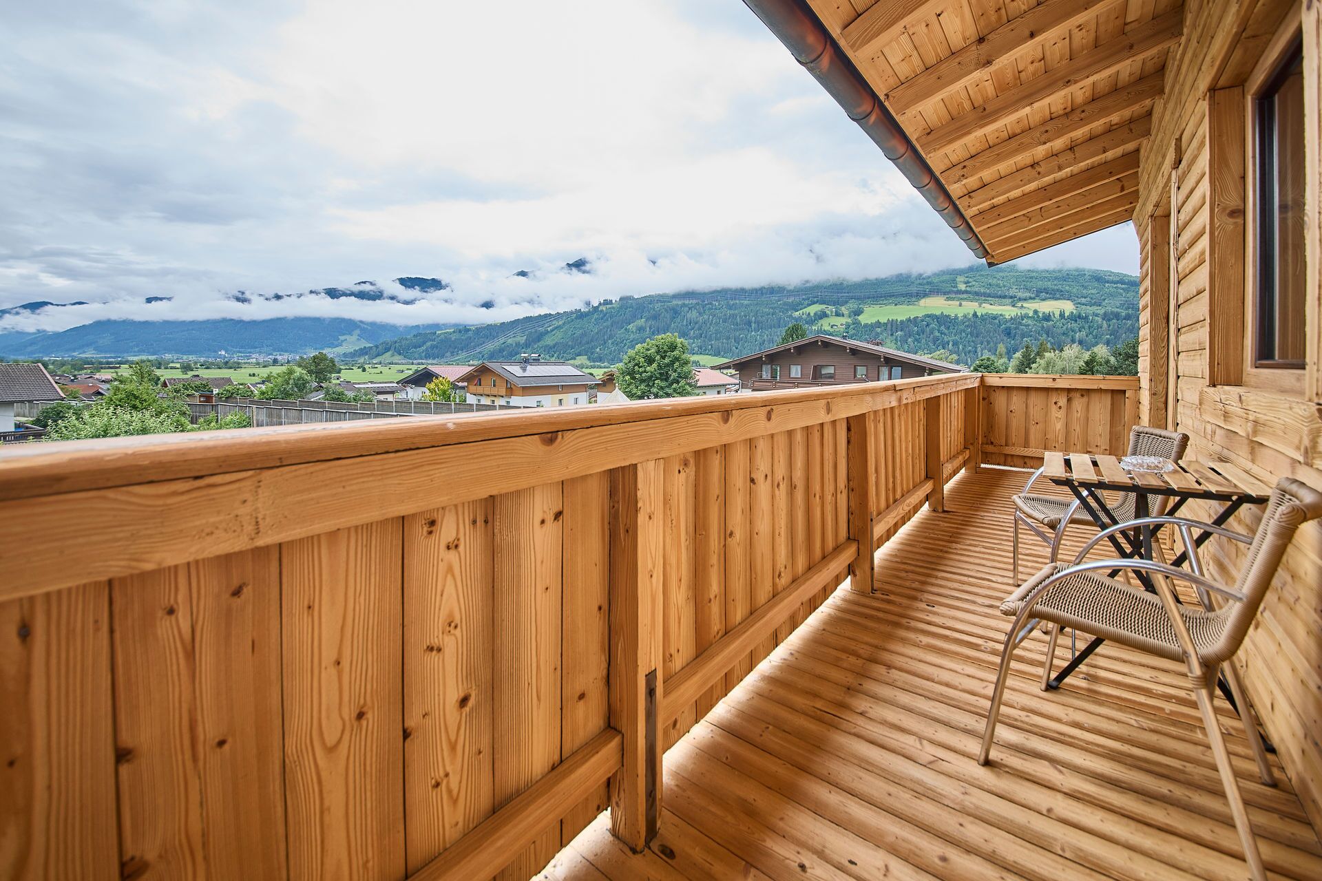 Un balcone in legno con vista su un paesaggio montano.