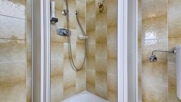 Ducha con puerta de vidrio, cabezal de ducha de mano y rociador de mano.