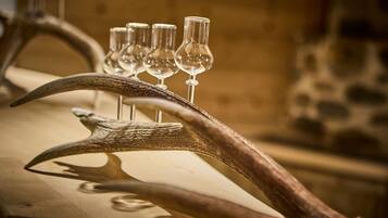 A table with a large antler and several wine glasses.