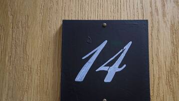 A black sign with the number 14 on a wooden surface.