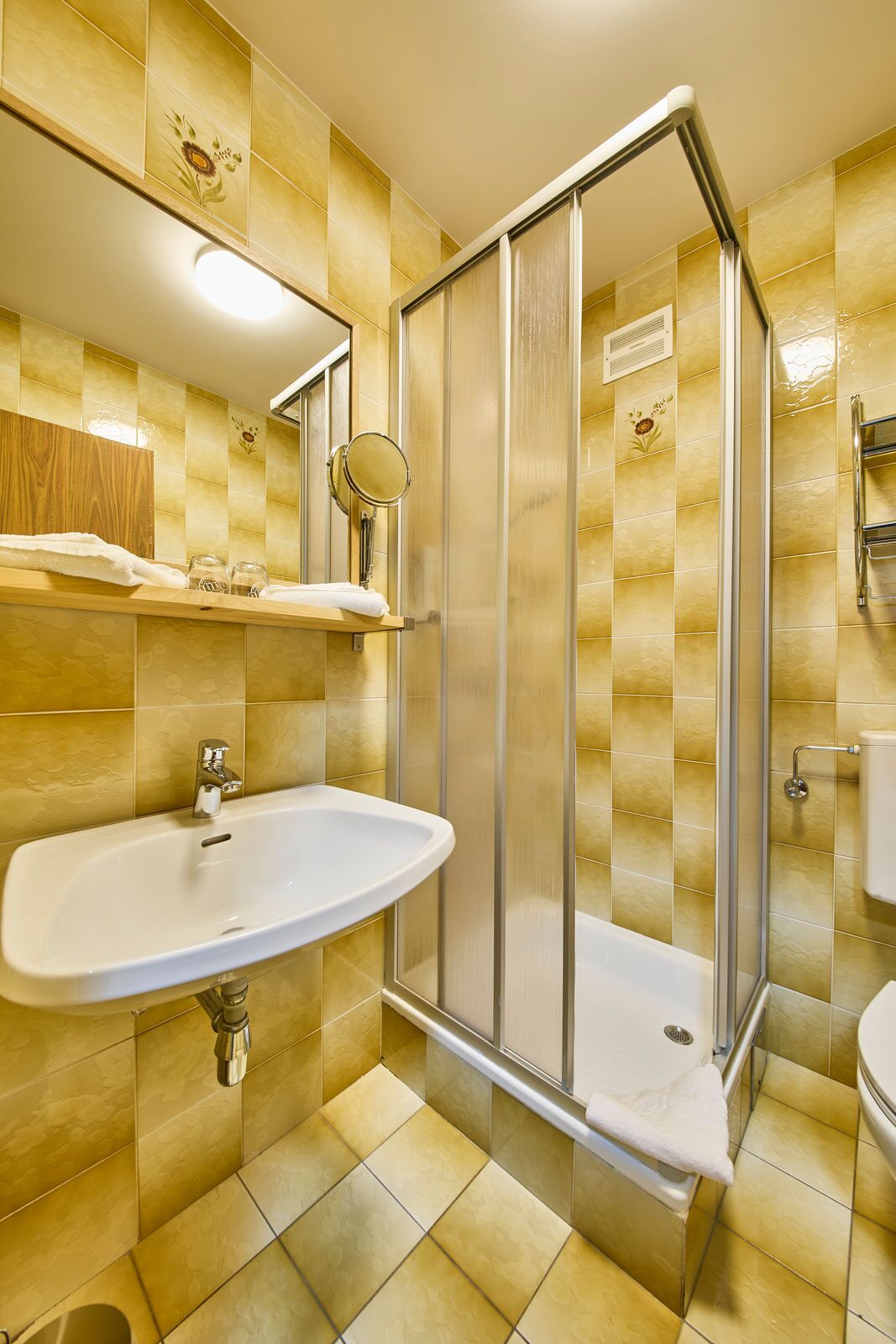 Un baño con cabina de ducha, lavamanos e inodoro.