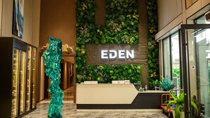 A reception desk with a green wall and the word "EDEN" above it. - Eden Hotel  (Kinshasa)