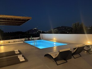 A rooftop pool with a view of a cityscape at night. - Serenity Bay, Cycladic Villa with Pool and magnificent view near the beach. (Leros)