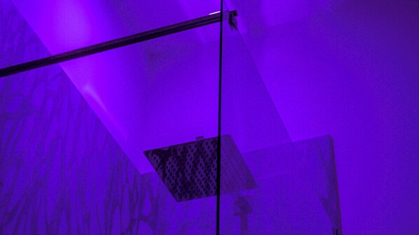 A room with a slanted ceiling and a hanging light fixture. - Luxury Triple Room with City View (Roma)