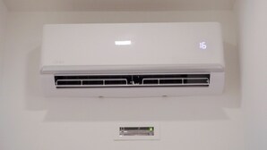A white wall-mounted air conditioner with a digital display showing the temperature as 16 degrees.