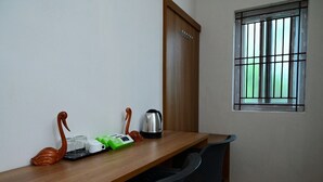 Une table en bois sur laquelle se trouvent une bouilloire, des tasses et une boîte verte, le tout flanqué de deux objets en forme de cygne.
