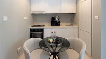 Departamento Deluxe, vista a la ciudad | Cocina privada | Refrigerador, microondas, horno y parrilla de estufa