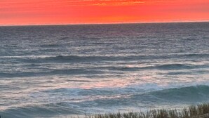 A sunset over the ocean with waves.