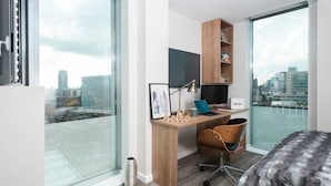 A modern bedroom with a city view, a desk with a computer, a chair, and a bed. - For Students Only Chapter South Bank in London (London)