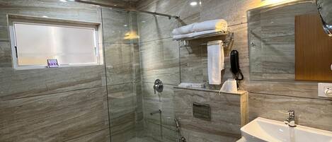 A modern bathroom with a glass-enclosed shower, a vanity with a sink, and a toilet.