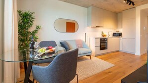 Een moderne keuken met witte kasten, een magnetron en een kleine oven.