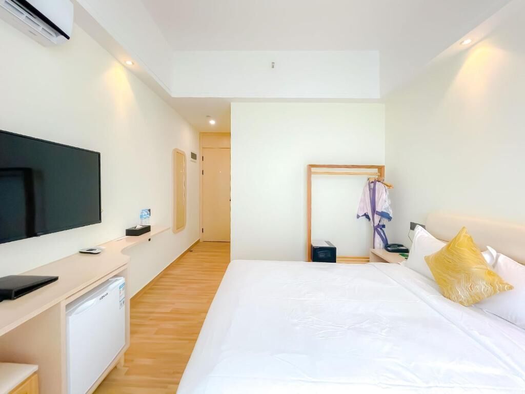 Una habitación de hotel con cama, televisión, escritorio y armario.