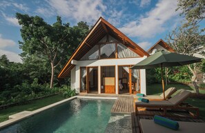 A modern house with a large glass window, a wooden deck, and a swimming pool. - Arpana Villas (Jimbaran)