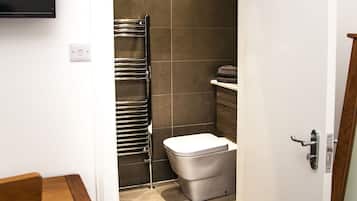 Een douche, handdoeken, zeep, toiletpapier