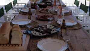 A table set for a meal with a view of the sea and mountains. - Experience your personal leap into time on Therasia island (Thirasia)
