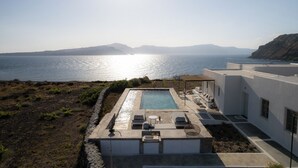 A modern pool area with a view of the sea and distant mountains. - Experience your personal leap into time on Therasia island (Thirasia)