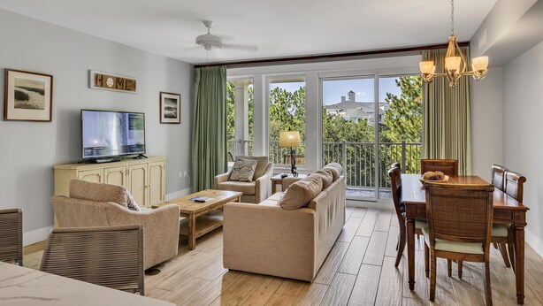 Un grand salon comprenant un canapé, des fauteuils, une table à manger et un téléviseur.