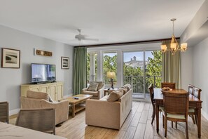 A spacious living area with a sofa, chairs, a dining table, and a television. - Charming 2BR Suite at Sandestin Golf & Beach Resort! (Miramar Beach)